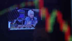 Corredores de bolsa permanecen en el parqué de la Bolsa de Valores de Nueva York, mientras en una pantalla se observa a la presidenta de la Reserva Federal (Fed) de EE.UU., Janet Yellen / EFE