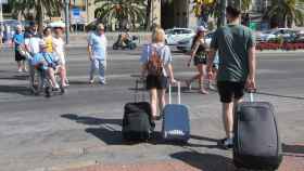 Turistas con maletas por las calles de Barcelona