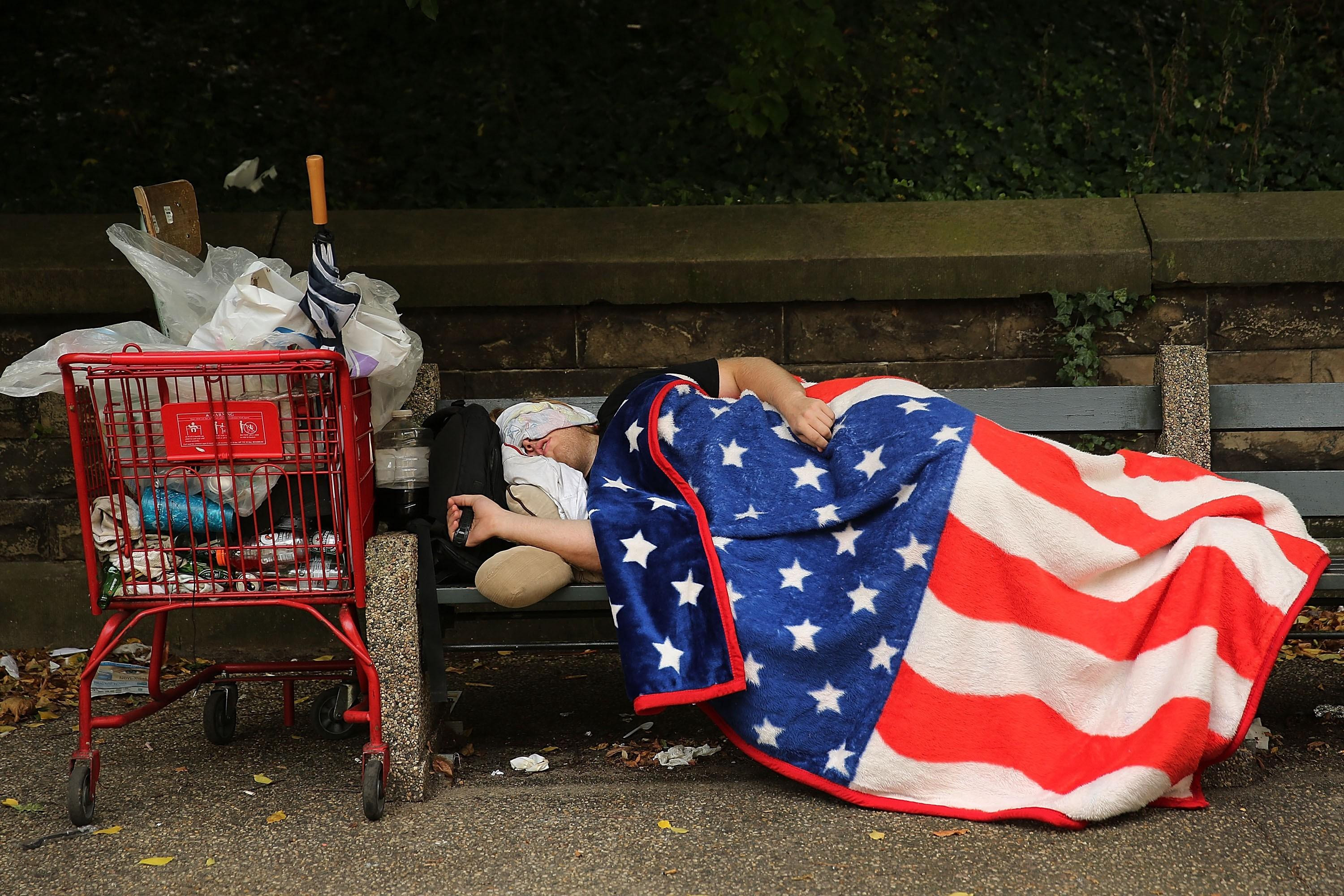 Un hombre sin hogar durmiendo en un banco en Estados Unidos
