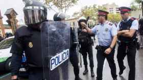 Dos agentes de los Mossos d'Esquadra hablan con otros tres de la Policía Nacional durante el referéndum del 1-O / EFE