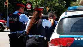 Dos agentes de los Mossos, arrestando a una persona por un presunto robo con violencia como los cometidos en Barcelona  / EP