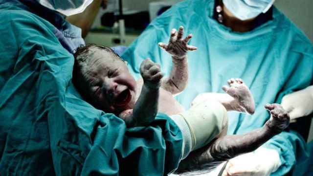 Un bebé llora en brazos de un médico / EP