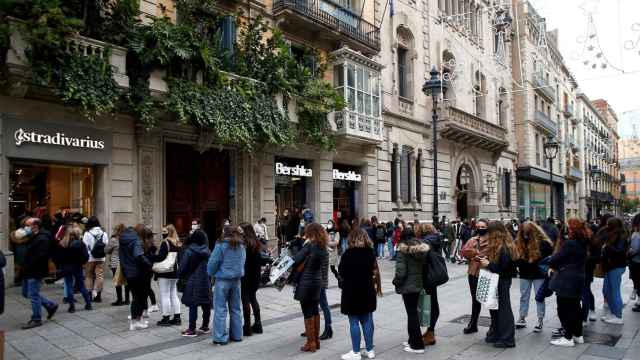 La gente se amontona en las aceras mientras hace cola para entrar en las tiendas del paseo de Gràcia / EFE