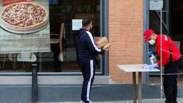 Un trabajador de Telepizza atiende desde la puerta durante la crisis del coronavirus / EUROPA PRESS