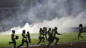Los policías, cargando contra algunos espectadores en Indonesia / EFE