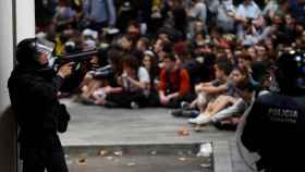 Un agente antidisturbios con una pistola de bolas durante la protesta en el aeropuerto, donde un hombre ha perdido un ojo / EFE