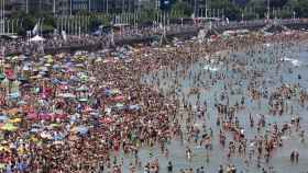 Llenazo en la playa de San Lorenzo, de Gijón, con bañistas que huyen del calor