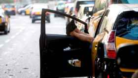 Un taxista descansa dentro de su vehículo en la Gran Vía de Barcelona / EFE