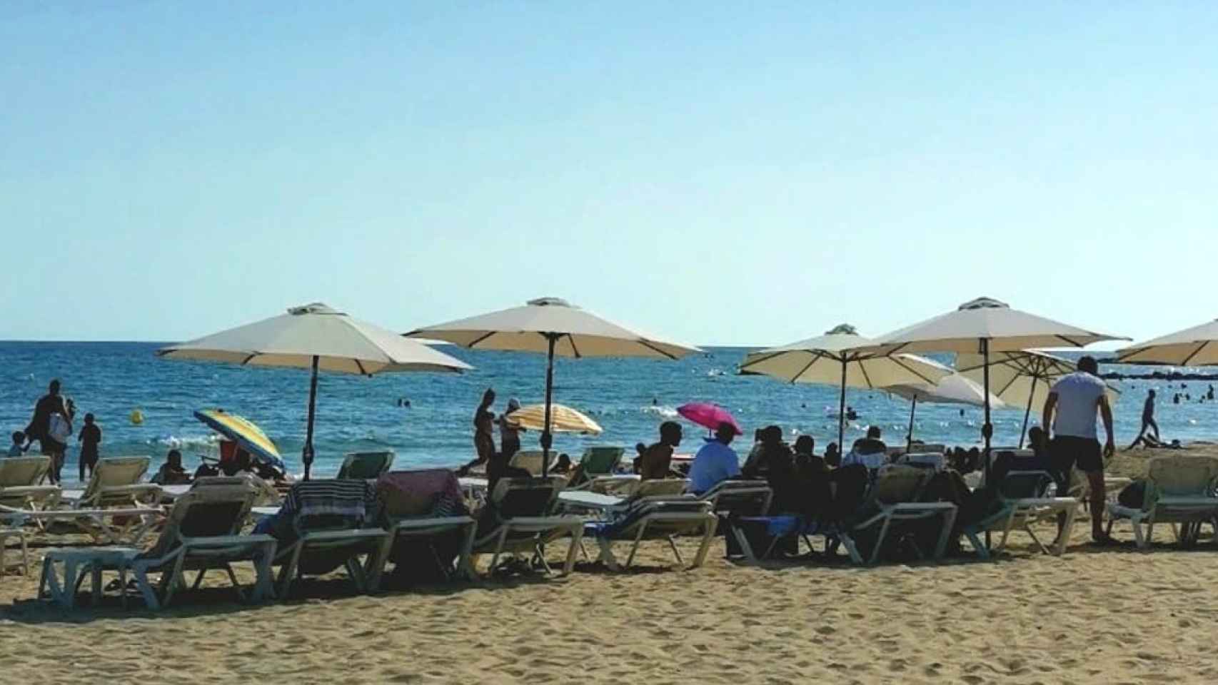 Una zona de playa con hamacas y sombrillas JN
