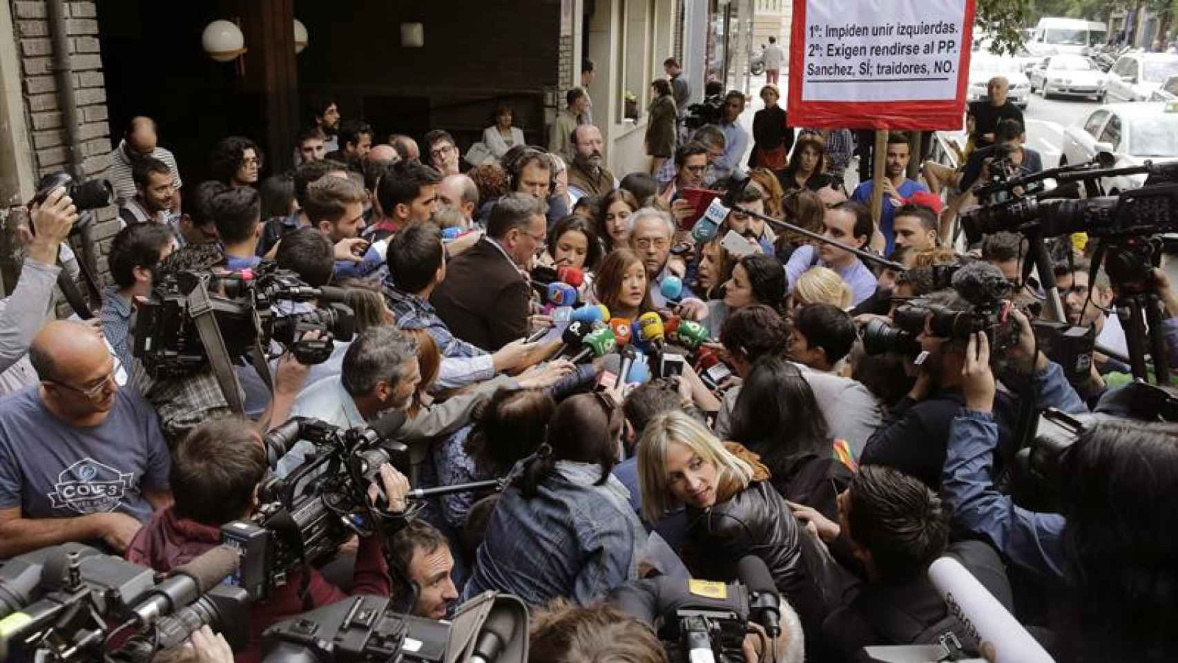 Una multitud de periodistas rodean a la presidenta del comité federal del PSOE, Verónica Pérez, a su entrada en la sede del partido / EFE
