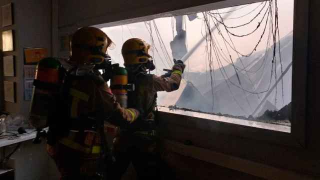 Imagen de archivo de dos bomberos trabajando en el incendio de una fábrica algodonera Pagès Valentí, en Sant Jaume de Llierca / BOMBERS