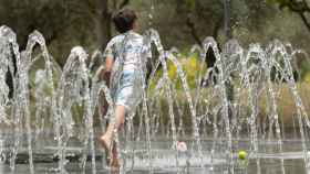 Un niño se moja en unos chorros durante la ola de calor / EUROPAPRESS