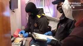 Registro de la Guardia Urbana y los Mossos d'Esquadra en el domicilio del barrio de Baró de Viver de Barcelona, donde las dos personas detenidas presuntamente traficaban con heroína / GUARDIA URBANA BARCELONA