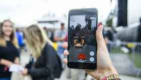 Una usuaria de Pokémon Go muestra su móvil mientras juega con la app