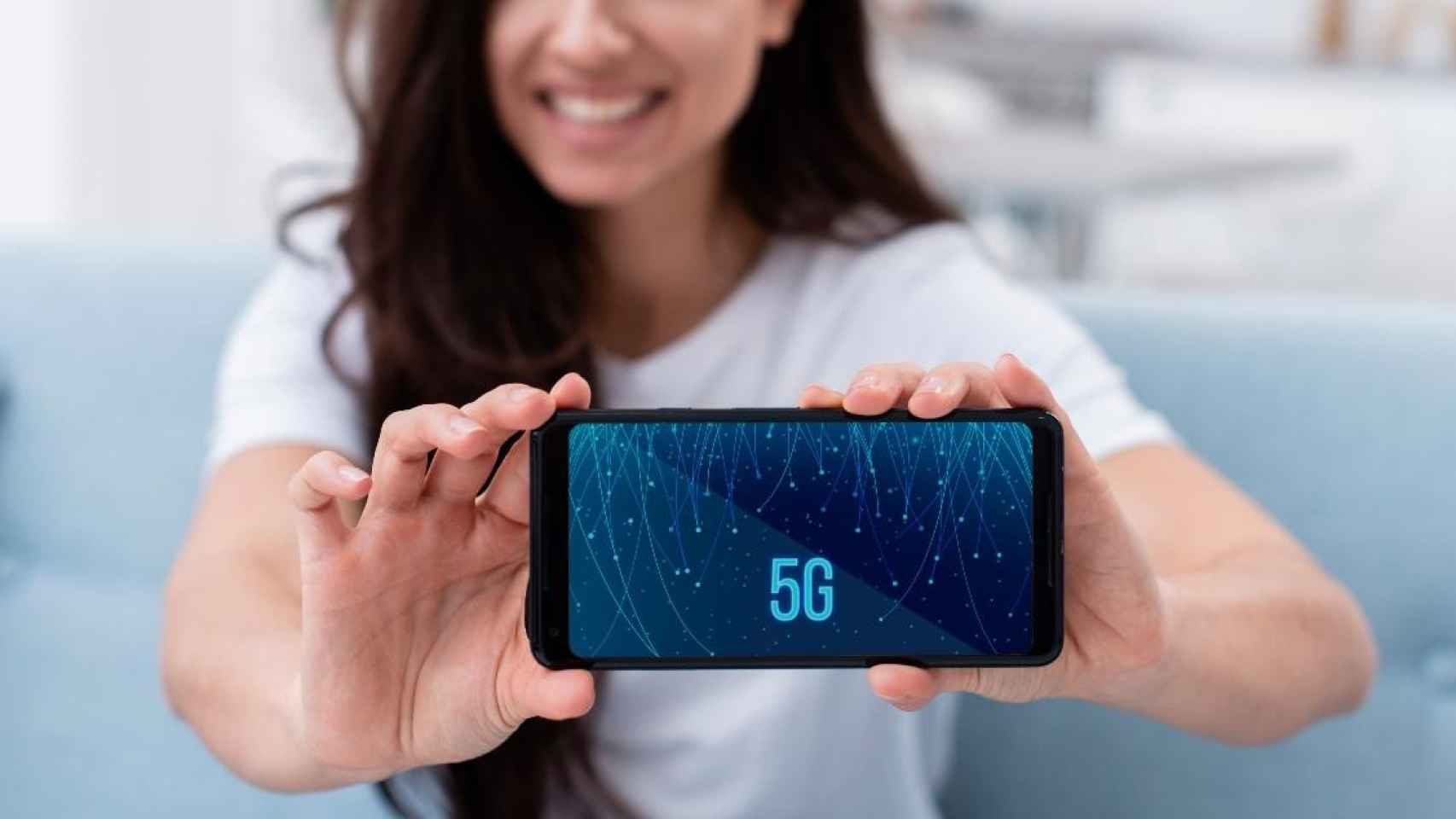 Una mujer sujeta un móvil con conexión 5G / FREEPIK