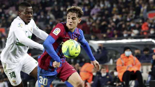 Gavi, protegiendo el esférico contra un jugador del Elche / EFE