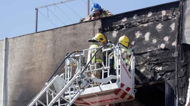 Los bomberos en el incendio en un bloque de Badalona / EFE