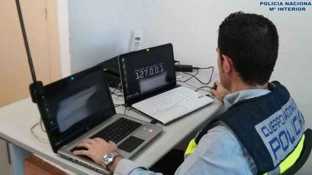 Un agente del CNP analiza el ordenador de un presunto estafador por el método phishing, en una imagen de archivo  / EUROPA PRESS