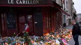 Un parisino observa las flores despositadas ante uno de los restaurantes que fueron objetivo de los terroristas.