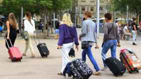 Varios turistas arrastran sus maletas en el barrio de la Barceloneta de la capital catalana / EFE