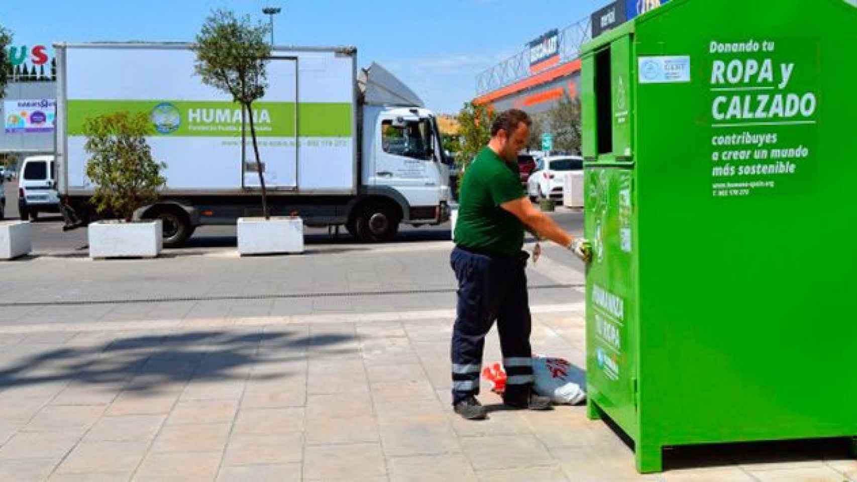 Un operario municipal recoge ropa y calzado reciclas en un contenedor de basura especializado / EFE