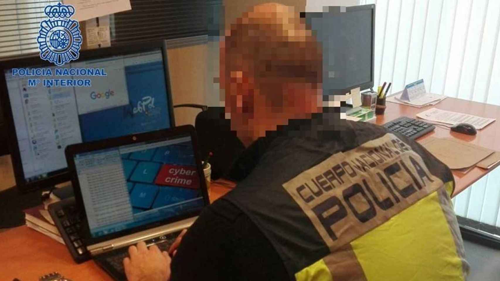 Un agente de la Policía Nacional analiza un ordenador como los usados por la cúpula de una academia de ‘trading’ por captar menores con la promesa de hacerles ricos / CNP