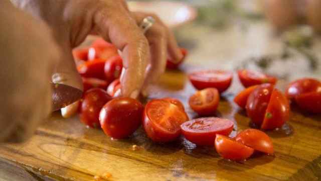 Una persona corta frutas y verduras en una tabla de cocina antes de comerlos / PIXABAY