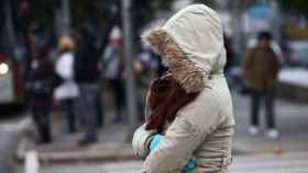 Una joven se protege del frío