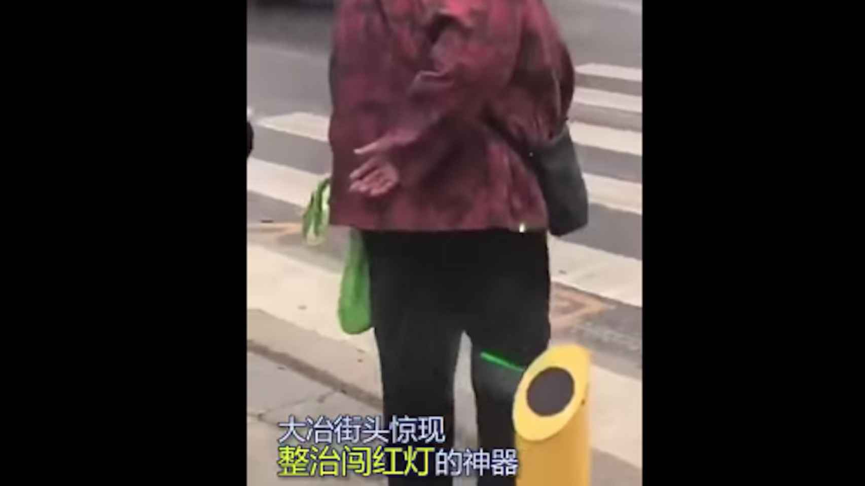 Una foto de una mujer mojándose con el chorro de agua por intentar pasar en rojo