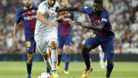 Umtiti lucha por un balón dividido con Benzema en el clásico / EFE