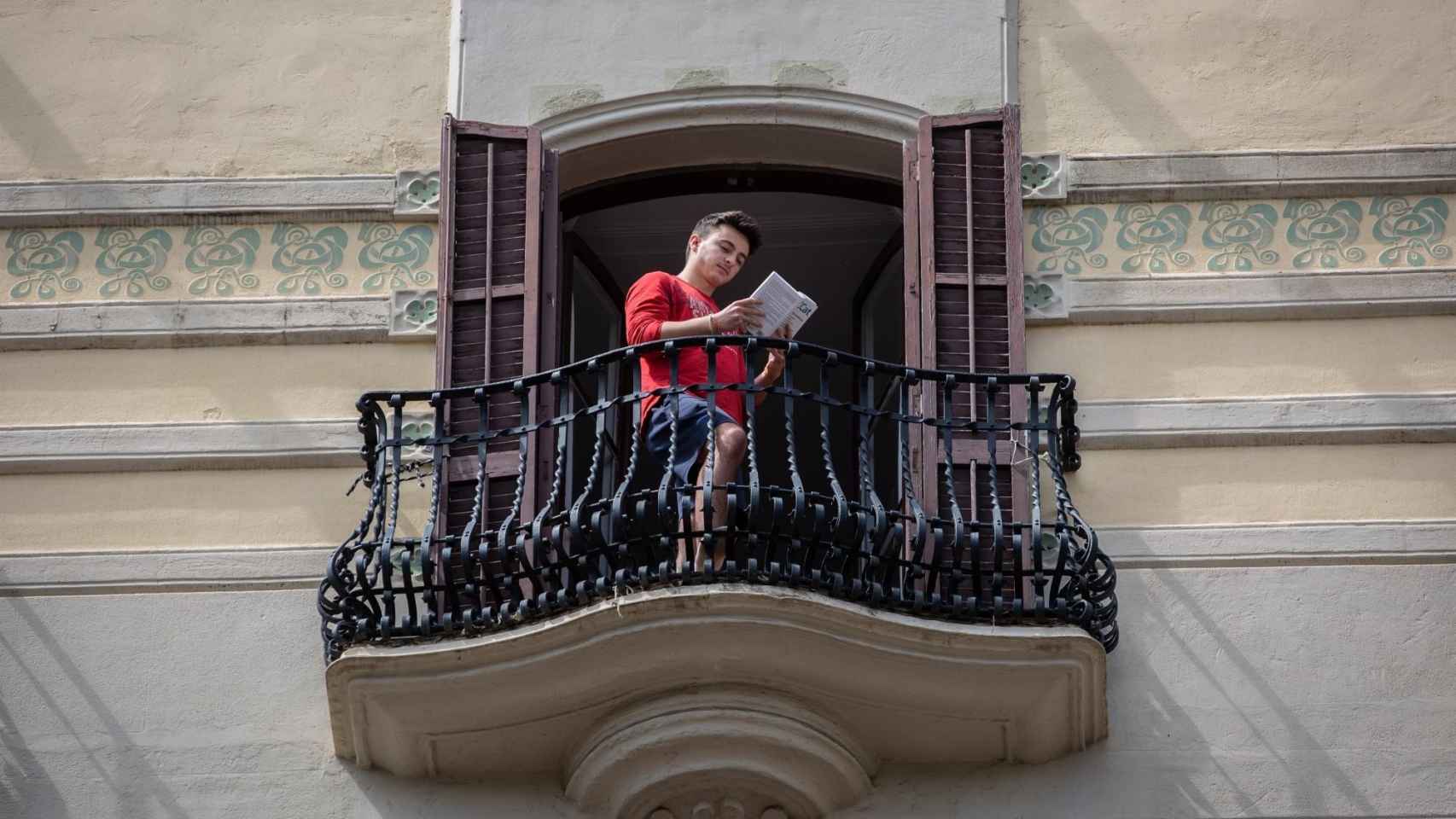 Un hombre leyendo un libro desde su balcón el día del Sant Jordi desde el encierro / EP