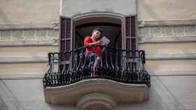 Un hombre leyendo un libro desde su balcón el día del Sant Jordi desde el encierro / EP