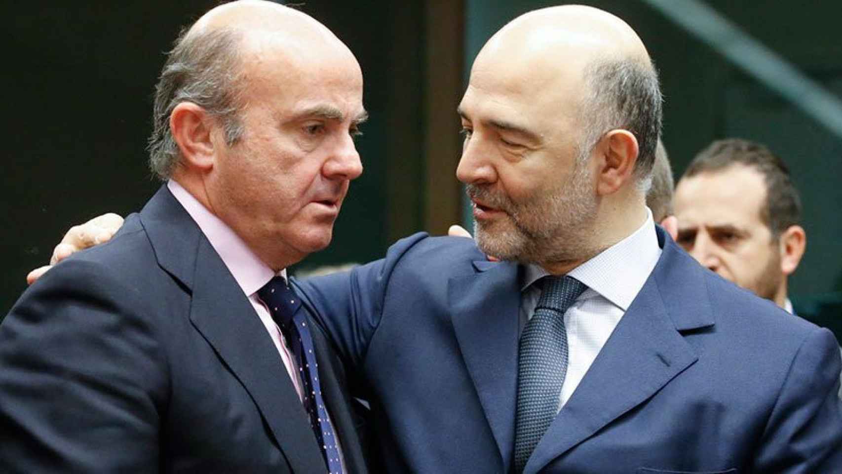 Pierre Moscovici, comisario europeo de Finanzas, saluda afectuosamente al ministro español de Economía, Luis de Guindos, en una imagen de archivo.