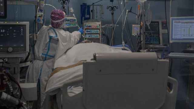Una enfermera atiende a un enfermo de Covid, que se reduce el número de positivos, pero la mortalidad sigue siendo alta/ David Zorrakino (EP)