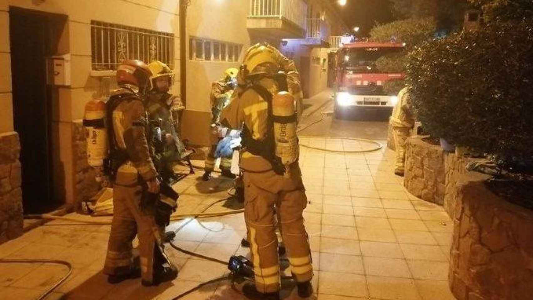 Efectivos de bomberos tras sofocar las llamas y rescatar a las dos personas intoxicadas en el incendio de esta noche en Cardona (Barcelona) / BOMBERS