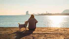 Imagen de una ciudadana con su perro con el hotel W Barcelona de fondo / CG
