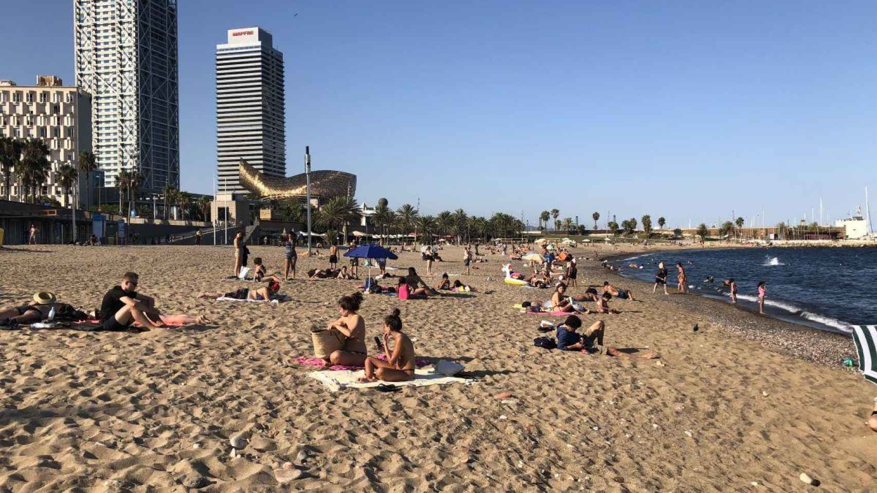 Bañistas toman el sol en la arena: 97 playas catalanas han obtenido el premio Bandera Azul 2021 / EP