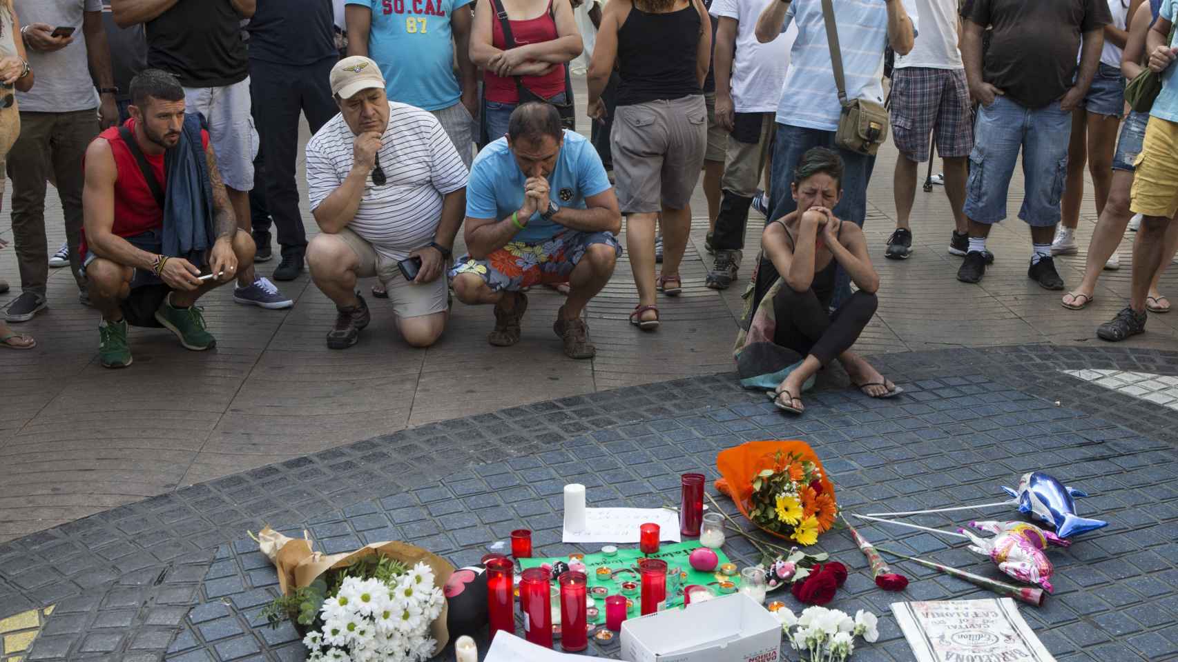 Homenaje improvisado a las víctimas sobre el mosaico de Joan Miró / EFE