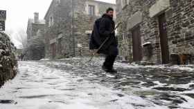 Un hombre camina por una calle nevada en Galicia / EFE
