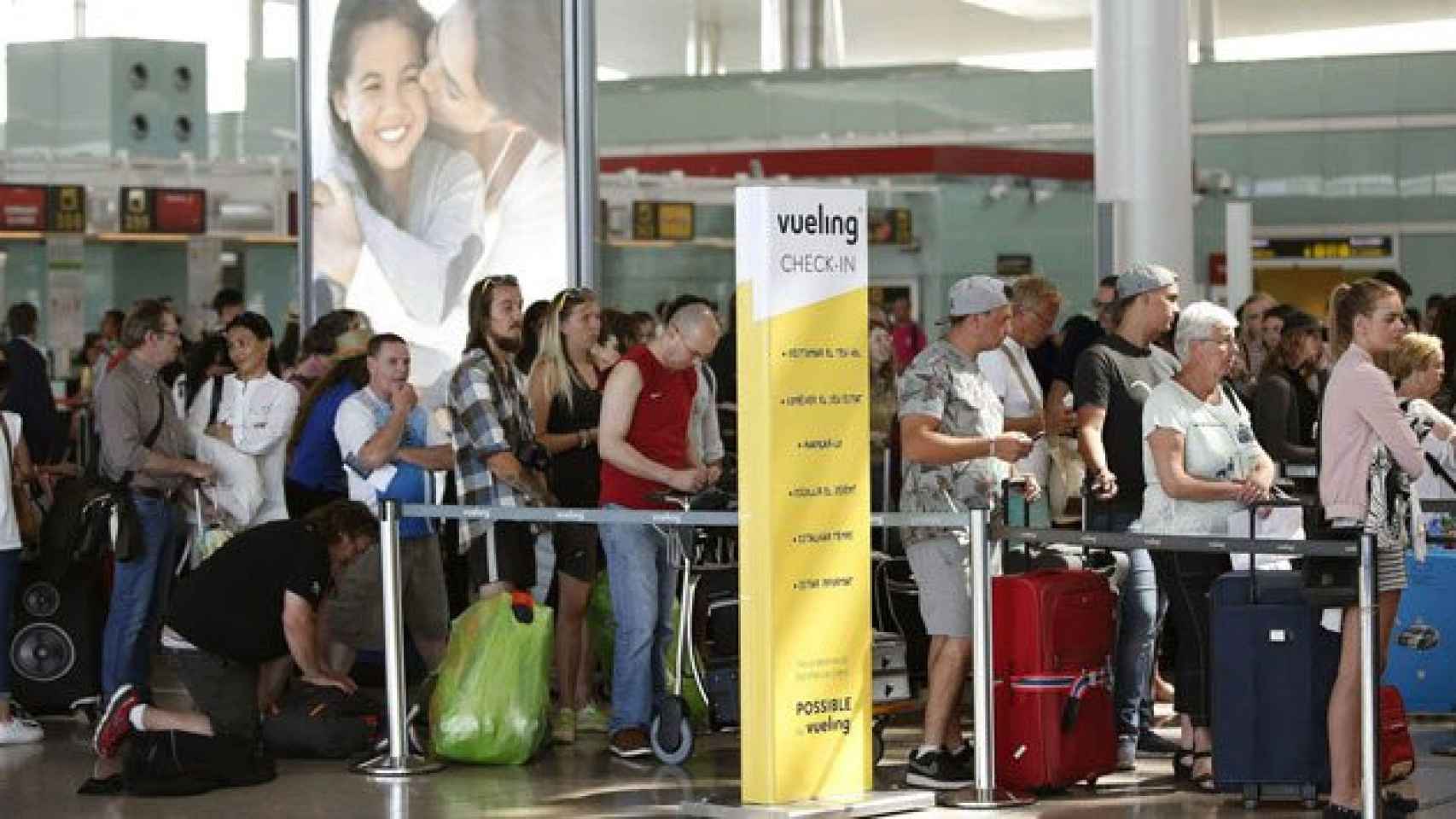 Cola de pasajeros en un mostrador de facturación de Vueling en el aeropuerto del Prat de Barcelona.