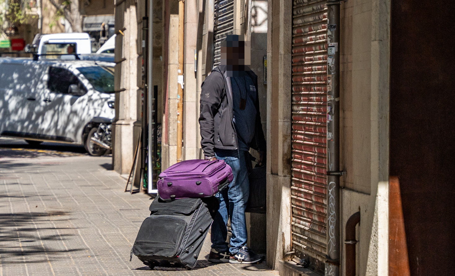 Una persona accede con varias maletas a la finca okupada en la calle Muntaner / CRÓNICA GLOBAL