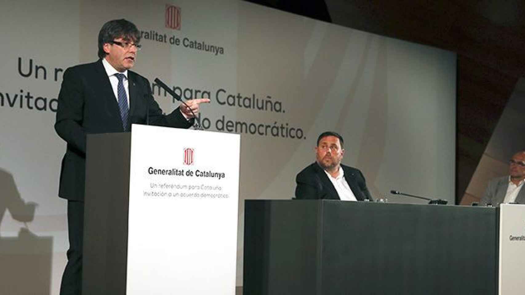 El presidente de la Generalitat, Carles Puigdemont, acompañado por el vicepresidente, Oriol Junqueras, y el consejero de Exteriores, Raül Romeva, durante su conferencia de este lunes en Madrid / EFE