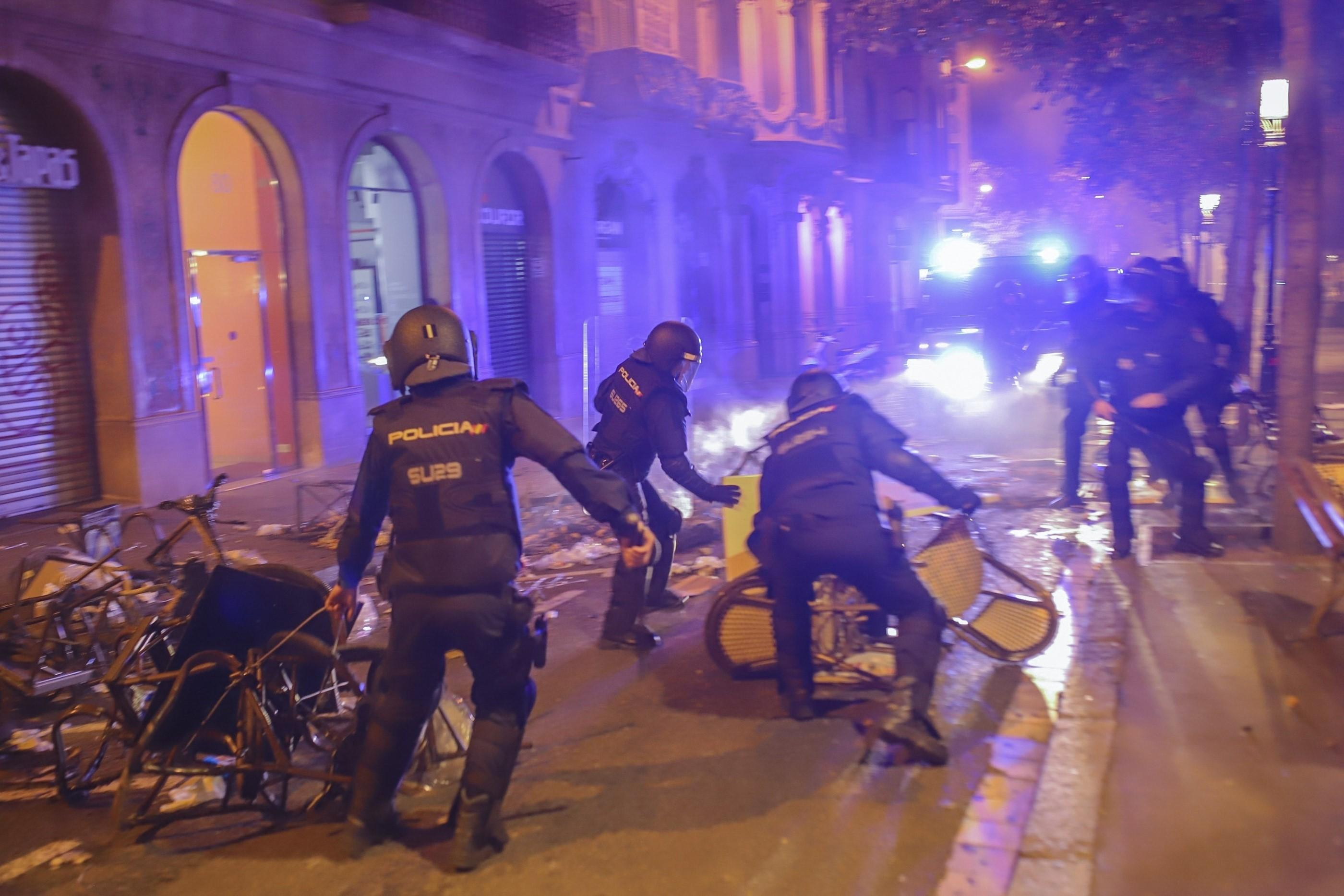 Policías quitando barricadas durante la cuarta noche de altercados en Barcelona