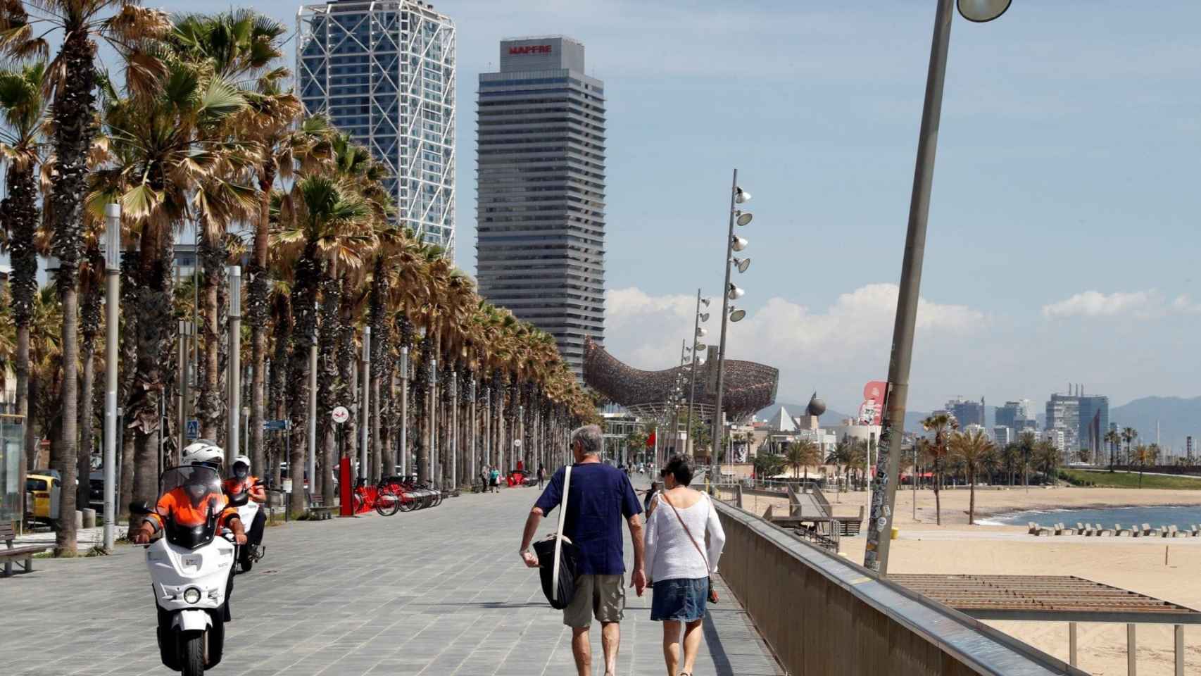 Dos personas caminan por el paseo marítimo de Barcelona / EFE