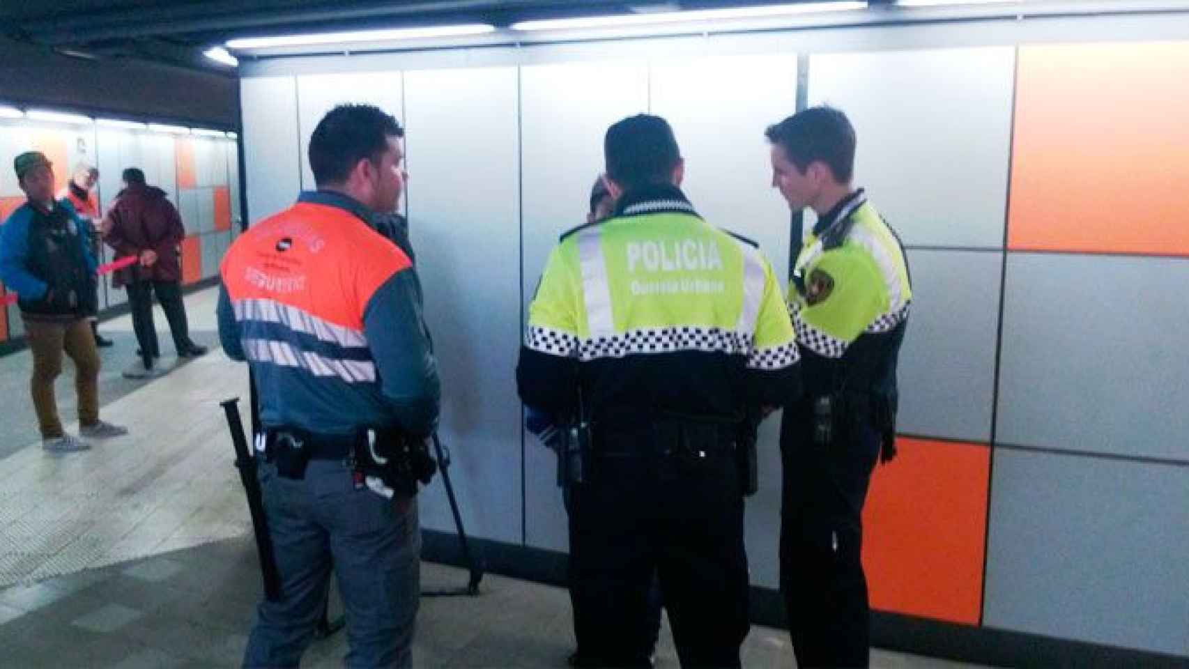 Un vigilante de seguridad del Metro de Barcelona, junto a dos agentes de la Guardia Urbana y una persona retenida / CG