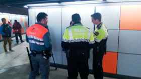 Un vigilante de seguridad del Metro de Barcelona, junto a dos agentes de la Guardia Urbana y una persona retenida / CG