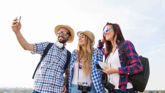 Tres amigos se hace una foto con el móvil / FREEPIK