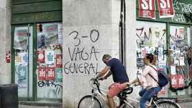 Unos ciclistas pasan ante unos carteles a favor del 3-O, un nuevo paro que Òmnium Cultural quiere repetir / EFE