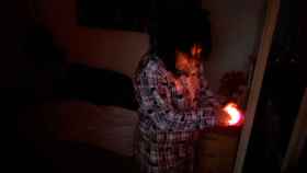 Isabel, vecina de la Barceloneta, alumbrando su vivienda con una vela durante el corte de luz / CG