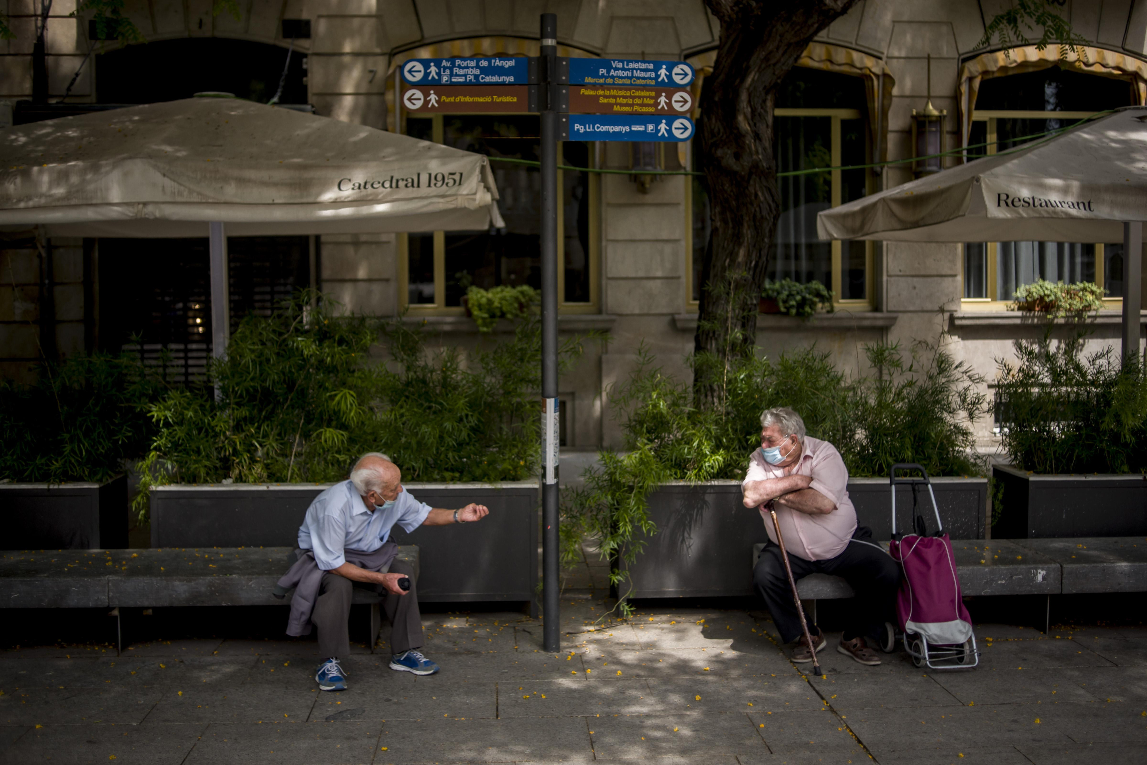 Dos ancianos mantienen la distancia social en una de las calles de Barcelona / EP
